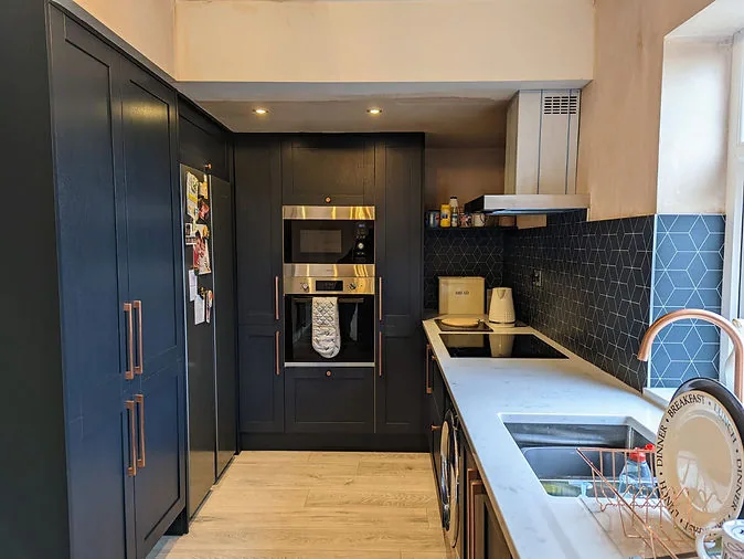 The renovated Earby kitchen with dark cabinetry and light worktops
